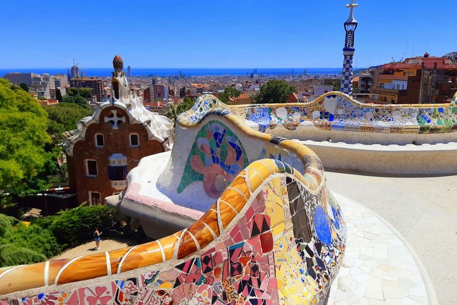 Vista panorámica de Barcelona desde el Park Güell, con mosaicos en primer plano y el mar al fondo