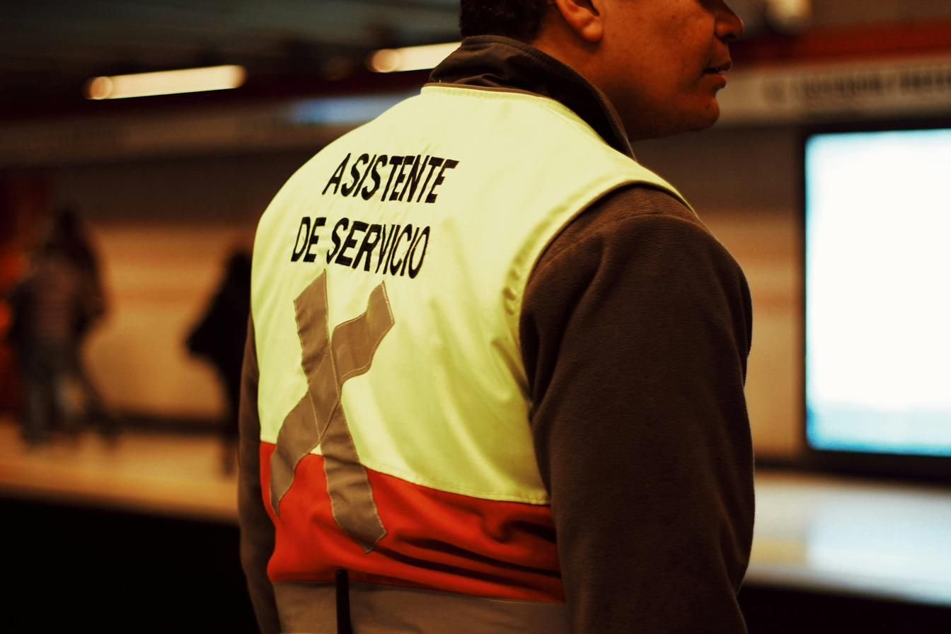 Trabajador con chaleco reflectante de asistente de servicio en el andén de una estación de metro